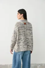 Sweater de punto con diseño jaspeado en tonos grises, cuello alto y corte holgado con mangas largas.