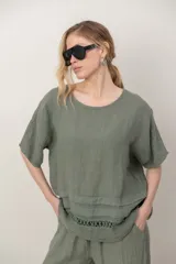 Blusa de lino color blanco, de corte amplio, con escote redondo, mangas cortas y detalle de guarda calada horizontal en la parte inferior.