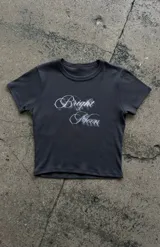 Remera crop gris oscuro de manga corta y cuello redondo, con estampa frontal con texto en tono claro.