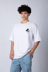Remera negra de corte oversize confeccionada en algodón pesado, con estampa pequeña de Mickey Mouse en el pecho y diseño gráfico en la espalda.
