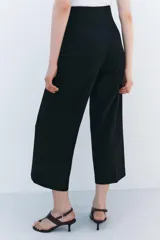 Pantalón tipo culotte de tiro alto, pierna ancha y pinzas frontales. Color beige/topo liso.