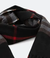Bufanda larga de poliéster con estampado de cuadros en tonos negro, marrón, gris y rojo. Termina en flecos.