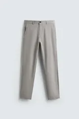 Pantalón chino de corte slim fit, color gris, confeccionado en tejido elástico. Cuenta con bolsillos frontales, bolsillos traseros de vivo con botón y cierre frontal con cremallera y botón.
