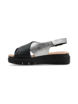 Sandalia de plataforma con tiras cruzadas en cuero negro y plateado, con ajuste de hebilla metálica lateral y suela de poliuretano.