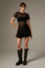 Short pollera negro de tiro alto con volados en el borde inferior.