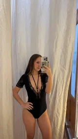 Body entallado de lycra color negro, con escote pronunciado decorado con encaje y microtul. Presenta mangas cortas de encaje y un collarín regulable desmontable integrado al diseño.