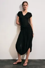 Vestido midi color negro de escote en V y manga corta, con detalle de fajín drapeado cruzado en la cintura y falda abullonada de corte asimétrico.