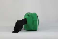 Riñonera verde de nylon con doble compartimento con cierre, ribete blanco decorativo y parche frontal con el logo de los Boston Celtics. Incluye correa negra regulable con hebilla.