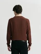 Sweater de punto con escote redondo, confeccionado en algodón con textura de punto fantasía en cuerpo y mangas, y terminaciones en punto canalé en cuello y puños.
