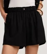 Short runner de viscolino, con cintura elástica, botón decorativo y bolsillos laterales. Presenta un corte evasé holgado con bajo redondeado.