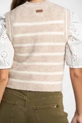 Chaleco de punto sin mangas con diseño de rayas horizontales en tonos beige y blanco, cuello redondo y terminaciones acanaladas.