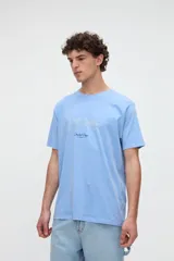 Remera celeste de manga corta y calce relaxed, confeccionada en jersey de algodón lavado con textura suave. Cuenta con un diseño en el pecho que combina estampa y bordado con la inscripción "Coastal Days 1956".