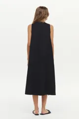 Vestido midi color crudo de corte relajado, con caída fluida, sin mangas y escote en V.