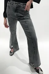 Pantalón jean gris de tiro medio alto, corte wide leg con tajo frontal.