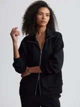 Campera negra de corte holgado con cierre bidireccional, cuello alto y bolsillos frontales.