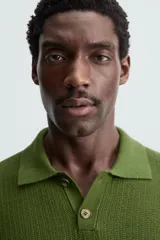 Polo de manga corta, corte regular fit, color verde oliva. Tejido de punto con textura acanalada vertical y cuello solapa con dos botones.