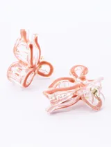 Set de dos pinzas para el pelo con forma de moño, color negro con borde transparente.