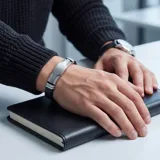 Pulsera masculina con diseño moderno que combina eslabones de acero inoxidable con una banda central de goma negra. Cuenta con un cierre de seguridad integrado.
