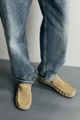 Mocasín casual de hombre fabricado en piel con acabado en serraje, de color tostado. Cuenta con detalle de bordón en el empeine, fruncido en la parte delantera, horma redonda y suela ultrafina.