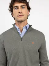 Sweater de punto color verde militar con cuello alto y medio cierre frontal de cremallera, manga larga y detalles acanalados en los puños y el dobladillo.