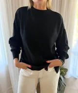 Sweater de punto acanalado color bordó, con cuello redondo, mangas largas con puños ajustados y diseño holgado con tajos laterales en el ruedo.