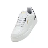 Championes urbanos Puma modelo Shuffle Downtown, de diseño clásico y perfil bajo. Presentan una capellada blanca con detalles en negro en la zona del talón y el logo de la marca en dorado. Cuentan con suela de goma y sistema de cordones.