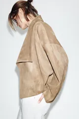 Chaqueta de efecto ante con cuello solapa envolvente, manga larga con hombro caído y bajo con elástico interior. Cuenta con bolsillos laterales ocultos en costura y forro interior.