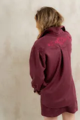 Camisa estilo western confeccionada en gamuza sintética color bordó, con diseño holgado y bordado geométrico en la parte superior de la espalda.