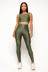 Top deportivo color terracota, de corte crop y manga sisa, con cuello redondo y espalda escotada. Presenta textura acanalada y acabado brillante.