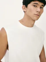 Musculosa beige de corte clásico con cuello redondo y sisas amplias.