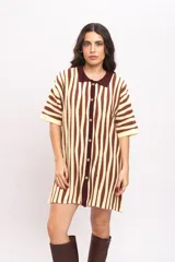 Vestido camisola de tejido de punto fresco, con rayas verticales en tonos marrones y beige, cuello polo marrón, mangas cortas y cierre frontal con botones de madera.