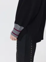 Pullover de cuello tortuga color marrón, de corte holgado y diseño básico. Presenta puños acanalados en contraste de color bordó con líneas horizontales celestes.