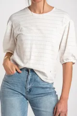 Remera off-white con mangas abullonadas y cuello redondo, confeccionada en algodón con elastano.
