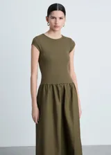 Vestido midi de diseño combinado en color verde oliva. Presenta un cuerpo ajustado de tejido de punto con cuello redondo y mangas cortas, unido a una falda amplia de corte evasé confeccionada en algodón.