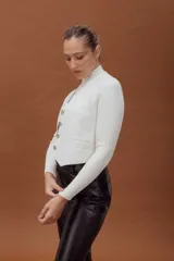 Chaleco de cuero ovino con diseño sastrero minimalista, escote en V, cierre frontal con botones y bolsillos laterales con vivo.