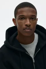 Campera con capucha y cierre frontal, de tejido pesado de mezcla de algodón con interior cepillado suave. Modelo con hombros caídos, capucha forrada en punto con cordón para ajustar y bolsillos delanteros. Puños y bajo acanalado.