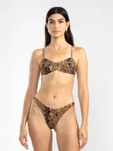 Conjunto de bikini de dos piezas con estampado animal print en tonos marrón y negro. El corpiño es tipo triángulo con breteles finos ajustables y la bombacha es de tiro bajo con cobertura mínima.