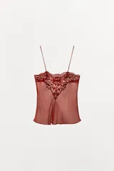 Musculosa de georgette en color bordó, con escote recto, tirantes finos y detalle de aplicación de encaje floral en la parte superior.