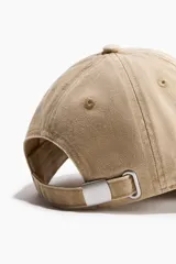 Gorra de sarga de algodón en color beige con efecto lavado, visera curva y diseño bordado en azul marino en el frente con el texto 'Rowing Club Est 1986 Riverside Park'.