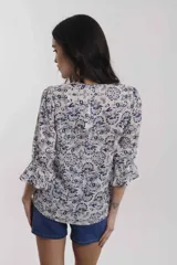 Camisa estampada con flores rojas sobre fondo rosa, con escote en V y mangas 3/4 con volados.