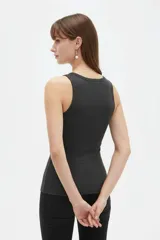 Musculosa de canalé color verde oliva, con breteles anchos, escote redondo y diseño ajustado al cuerpo.