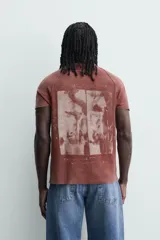 Remera de punto de algodón con efecto lavado, corte relajado, cuello redondo y mangas ranglán cortas. Presenta estampados a contraste en la parte delantera.
