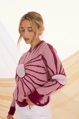 Sweater de punto color crema con diseño de flor en el frente, con detalles en lila y amarillo.