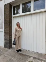 Saco tipo cardigan cruzado de lanilla color beige, con mangas largas y lazo ajustable en la cintura.