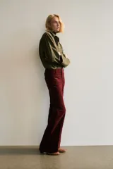 Pantalón de pana color bordó, de tiro alto, con bolsillos de parche delanteros y traseros. Presenta cierre con botón y piernas acampanadas con pliegues.