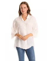 Camisa de algodón broderie color blanco, marca Liv Los Ángeles. Cuello con solapa, abertura central con botones y mangas ¾ amplias.