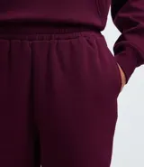 Pantalón jogger de corte holgado, confeccionado en tejido fleece color beige. Presenta cintura elástica, bolsillos laterales y puños ajustados en el bajo.