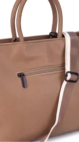 Cartera de formato amplio y estructurado, color marrón, con doble asa de mano y correa larga desmontable y regulable que permite llevarla al hombro o cruzada. Cuenta con cierre superior y aplique decorativo en el frente.