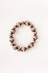 Pulsera elástica con cuentas redondas de diferentes tamaños en color cobre con efecto ojo de gato.