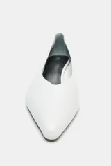 Zapato de tacón tipo kitten, confeccionado en piel soft color blanco, con diseño de escote en pico, acabado en punta y tacón fino.